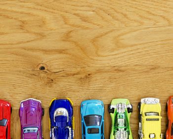 miniature cars in different colors lined up on a wooden floor