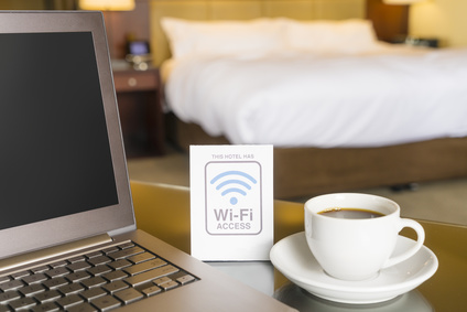 Hotel room with wifi access sign, laptop and cup of coffee