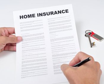 closeup of a young man signing a home insurance policy